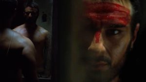 Saif Ali Khan as Langda Tyagi looking into a shattered mirror in a gritty scene from the Bollywood movie Omkara.